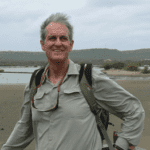 Sam Pickering smiles at the camera on the beach