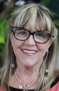 Author and editor, Susan Cushman. She has shoulder length hair with blond streaks and horn-rimmed glasses over a big smile. 