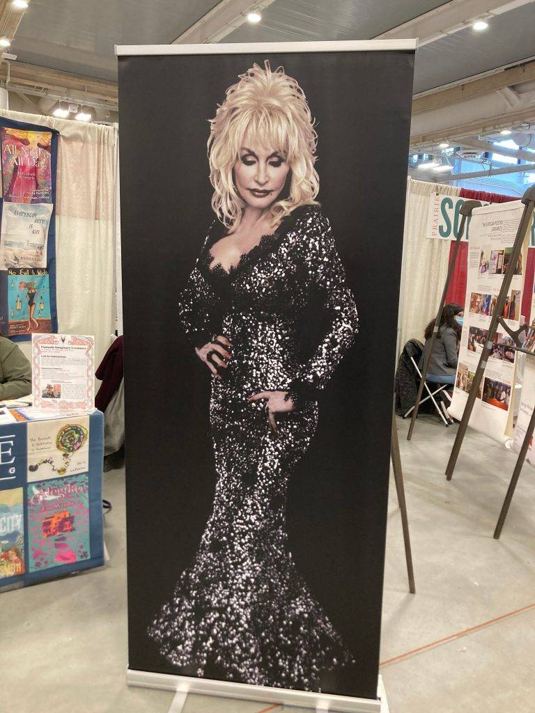 Queen Dolly regally awaits selfies with fans at the Book Fair! Photo by Lee Zacharias. Photo by Lee Zacharias.