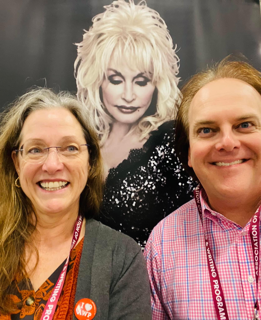 Madville Publishing founder Kim Davis and author Stephen Powers take a photo in front of the Dolly poster.