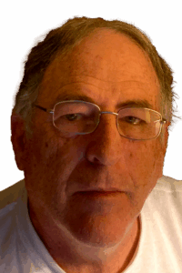 Author Bob Kunzinger looking serious. He is a white man wearing a white t-shirt. His hairline isn't where it used to be, and he wears wire rimmed glasses.